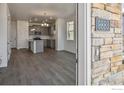 View from the doorway of the modern kitchen with island, gray cabinets and the dining area at 9857 Biscay St, Commerce City, CO 80022