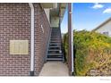 Exterior view of the apartment stairs, mailboxes, brick wall, and trimmed bush at 9868 Appletree Pl, Thornton, CO 80260