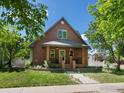 Charming brick home with landscaped yard, mature trees, walkway and cozy front porch at 101 Se 2Nd St, Berthoud, CO 80513