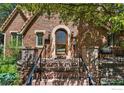 Inviting front porch showcasing brick pillars, wrought iron railing, and arched entryway to a charming brick home at 1035 Spruce St, Boulder, CO 80302