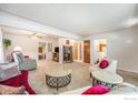 Spacious living room features plush carpeting, comfortable seating arrangements, and neutral tones at 1275 Walnut St, Brighton, CO 80601
