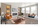 Elegant living room with a modern fireplace, stylish decor, comfortable seating, and lots of natural light at 13802 Quartz St, Mead, CO 80504