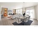 Open concept living and dining area featuring sleek furniture, modern lighting, and a cozy fireplace at 13802 Quartz St, Mead, CO 80504