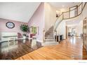 Spacious home foyer with hardwood floors, curved staircase and a view into other rooms at 13971 Telluride Dr, Broomfield, CO 80020