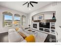 Elegant living room with fireplace, built-ins, and large windows offering scenic views at 15156 W Baker Pl, Lakewood, CO 80228