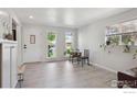 Bright living room featuring tile floors, multiple windows, and a welcoming entryway with coat hooks at 1610 Vivian St, Longmont, CO 80501