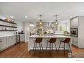 Stylish kitchen with a large center island, pendant lighting, bar stool seating, and modern appliances at 19061 Eagle Ridge Dr, Golden, CO 80401