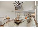 Bright living room with soaring ceilings, a decorative fireplace, and an open floor plan to the kitchen at 19061 Eagle Ridge Dr, Golden, CO 80401