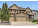 Beautiful two-story home featuring a three-car garage, stone accents, and a lovely front yard tree at 2165 Summerlin Ln, Longmont, CO 80503