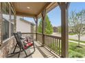 Inviting porch with wooden pillars, railing, and rocking chairs; perfect for relaxing outdoors at 2165 Summerlin Ln, Longmont, CO 80503
