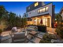 Inviting backyard with stone patio, modern furniture, and privacy provided by lush evergreens and manicured plants at 2248 S Lincoln St, Denver, CO 80210