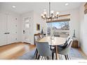 Bright dining room with a modern chandelier, wood table, and large windows overlooking the neighborhood at 2248 S Lincoln St, Denver, CO 80210