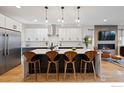 A sleek modern kitchen with stainless steel appliances, a center island with seating, and a cozy fireplace in view at 2248 S Lincoln St, Denver, CO 80210