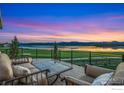 Relaxing outdoor deck offering comfortable seating, a scenic lake view, and a stunning sunset at 2387 Harding Park Ct, Berthoud, CO 80513