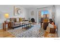Bright living room features hardwood floors, stylish furniture, decorative fireplace, and sliding glass doors to balcony at 252 N Pennsylvania N St # 305, Denver, CO 80203