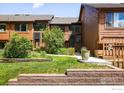Townhouse exterior boasts a well-maintained lawn, garden beds, and a wooden facade with large windows at 2725 Juniper Ave # 78, Boulder, CO 80304