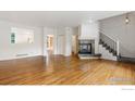 Bright, open-concept living area with hardwood floors, a cozy fireplace, and staircase access to upper level at 2982 W Long Dr # C, Littleton, CO 80120