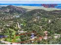 An aerial view of the property surrounded by trees and mountain views at 335 Pine Tree Ln, Boulder, CO 80304