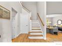 Bright foyer with hardwood floors, staircase, and view into the dining room at 5348 Wild Dunes Ct, Boulder, CO 80301