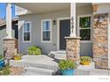 Inviting front porch with stone pillars, decorative plants, and the house number displayed at 6681 6Th St, Frederick, CO 80530