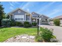 Inviting single-story home showcasing lush landscaping and a charming covered porch area at 8852 E 152Nd Ct, Thornton, CO 80602