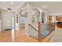 Elegant foyer featuring hardwood floors, arched entryways, and a staircase with decorative iron railings at 8852 E 152Nd Ct, Thornton, CO 80602