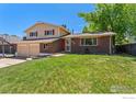 Charming two-story home features a well-maintained lawn, brick accents, and a two-car garage at 9084 W Rice Ave, Littleton, CO 80123