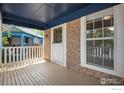 Charming brick front porch with ample space and a traditional white screen door at 911 Homer Cir, Lafayette, CO 80026