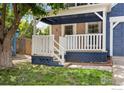 Inviting covered front porch with white railings and brick accents, perfect for relaxing outdoors at 911 Homer Cir, Lafayette, CO 80026