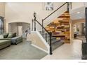 Grand foyer with a decorative wood accent wall, staircase, and open views to the living spaces at 10278 Dover St, Firestone, CO 80504