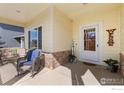 Inviting front porch with rocking chair and decor, features stone accents and welcoming entrance at 10278 Dover St, Firestone, CO 80504