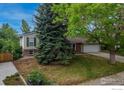 Charming single-Gathering home with a well-maintained lawn and mature trees, accented by a red front door at 117 Sandler Dr, Lafayette, CO 80026