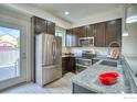 Modern kitchen featuring stainless steel appliances, granite countertops, and dark wood cabinets at 1240 Wren Ct # B, Longmont, CO 80501