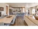 Open-concept kitchen flows into the living area with hardwood floors throughout at 12556 W Montane Dr, Broomfield, CO 80021