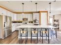 Modern kitchen features stainless steel appliances, a large island, and pendant lighting at 12556 W Montane Dr, Broomfield, CO 80021