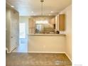 Open kitchen with stainless steel appliances and natural wood cabinetry at 13624 Garfield St # B, Thornton, CO 80602