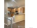 Open kitchen with stainless steel appliances and natural wood cabinetry at 13624 Garfield St # B, Thornton, CO 80602