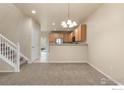 Open-concept living area leads into the kitchen, featuring new carpet and neutral decor at 13624 Garfield St # B, Thornton, CO 80602