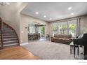 Open-concept living room with plush carpet, many windows, and adjacent dining area at 15562 E 109Th Ave, Commerce City, CO 80022