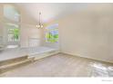 Bright living room featuring neutral carpeting, soaring ceilings, large windows, and a view into the adjacent dining area at 1638 E 131St Cir, Thornton, CO 80241