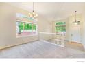 Bright living room featuring neutral carpeting, soaring ceilings, large windows, and a view into the entryway at 1638 E 131St Cir, Thornton, CO 80241
