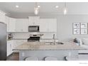 Modern kitchen showcasing granite countertops, stainless steel appliances, and sleek white cabinetry at 21823 E 8Th Ave, Aurora, CO 80018
