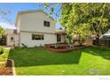 Expansive backyard featuring lush green lawn, mature trees, and a patio for outdoor enjoyment at 2421 Maplewood W Cir, Longmont, CO 80503