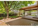 Large wooden deck with a covered area and a ceiling fan, perfect for entertaining outdoors at 2421 Maplewood W Cir, Longmont, CO 80503