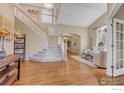 Bright foyer featuring hardwood floors, a staircase with white railings, and high ceilings at 2841 Silver Pl, Superior, CO 80027