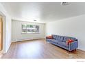 Bright living room showcasing hardwood floors, a cozy sofa, and a large window at 3375 Zephyr Ct, Wheat Ridge, CO 80033