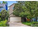 View of a home's garage with a neutral color scheme and lush green trees in a residential neighborhood at 4489 Wellington Rd, Boulder, CO 80301