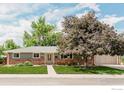 Charming single-story home with brick accents, a well-maintained lawn, and mature landscaping at 4601 S Lipan St, Englewood, CO 80110