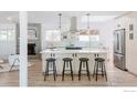 Modern kitchen features a large island with seating, stainless steel appliances, and stylish fixtures at 4601 S Lipan St, Englewood, CO 80110