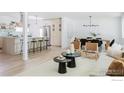 Open-concept living space with a dining area, modern furnishings, and light wood flooring at 4601 S Lipan St, Englewood, CO 80110
